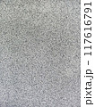 close-up texture shot of a rough, grey surface reminiscent of concrete or stucco. The granular quality and uneven shade variation make it suitable for backgrounds, graphic design 117616791