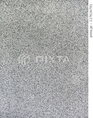 close-up texture shot of a rough, grey surface reminiscent of concrete or stucco. The granular quality and uneven shade variation make it suitable for backgrounds, graphic design 117616791