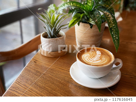 オシャレなカフェのテーブルの上にあるコーヒーカップ 117616845