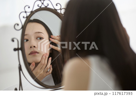 鏡で肌をチェックする女性 鏡で肌をチェックする女性 117617393