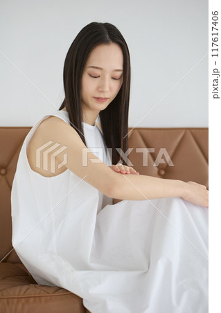 ソファーに座ってスキンケアをする女性 ソファーに座ってスキンケアをする女性 117617406