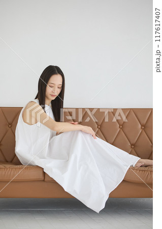 ソファーに座ってスキンケアをする女性 117617407