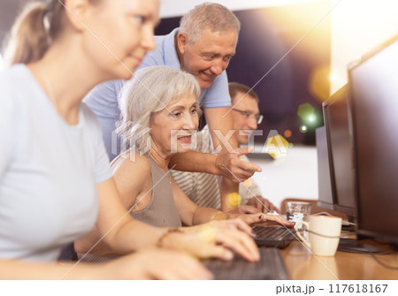 Senior woman attending computer class under guidance of aged teacher 117618167
