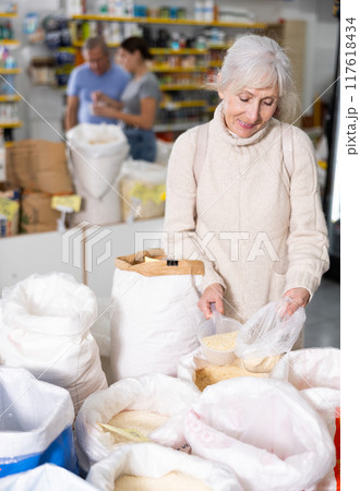 Old woman purchaser buying rice in big supermarket Old woman purchaser buying rice in big supermarket 117618434