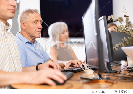 Focused senior man attending computer class for older adults Focused senior man attending computer class for older adults 117618500