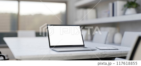 A laptop computer mockup on a white marble meeting table in a modern white meeting room. 117618855