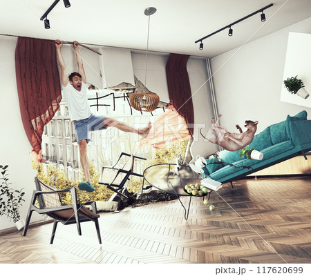 A man is hanging from a window and a cat is on the floor. 117620699
