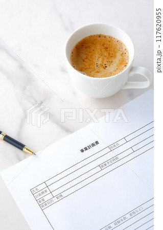 新規事業の立ち上げに先立ち、コーヒーを飲みながら、事業計画書を作成する 117620955
