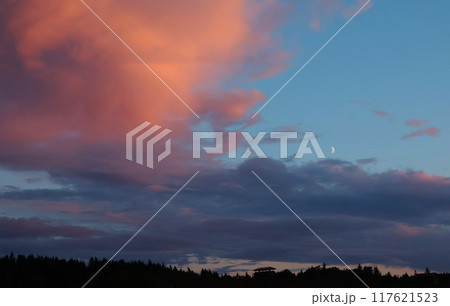 Pink and blue sunset over forest and village. Romantic dramatic background for design. Sky and clouds.  117621523