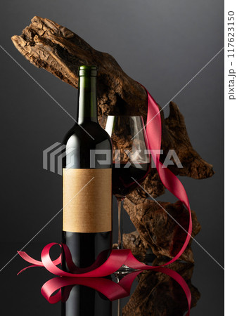 Bottle with old empty label and glass of red wine. Bottle with old empty label and glass of red wine. 117623150