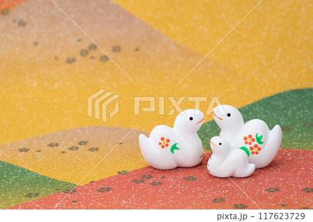 巳年　年賀素材　野山でお話をする紅白の巳の親子 117623729