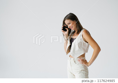 Young woman with a makeup palette in her hands on a white background. Cosmetic products 117624985