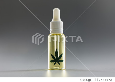 Hemp oil with a dropper on a gray background, close-up Hemp oil with a dropper on a gray background, close-up 117625578