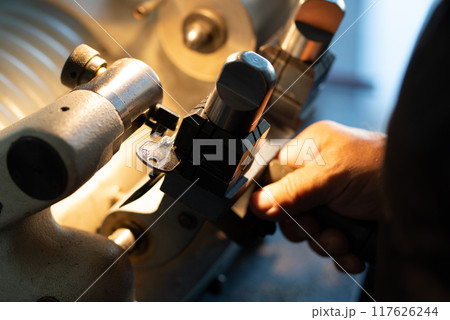 Hands are making dublicate of home keys manufacture Hands are making dublicate of home keys manufacture 117626244