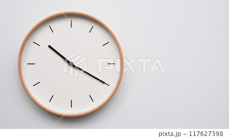 Minimalist wooden Wall Clock on White Wooden Surface with Space for Text. Time Set at 22.20/10.20 117627398