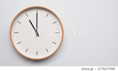Minimalist wooden Wall Clock on White Wooden Surface with Space for Text. Time Set at 23.00/11.00 117627406