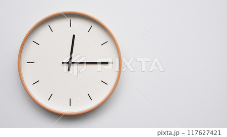 Minimalist wooden Wall Clock on White Wooden Surface with Space for Text. Time Set at 00.15/12.15 117627421