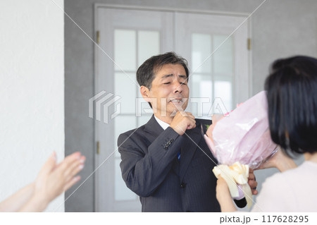 定年退職で家族から花束を受け取る父親 117628295