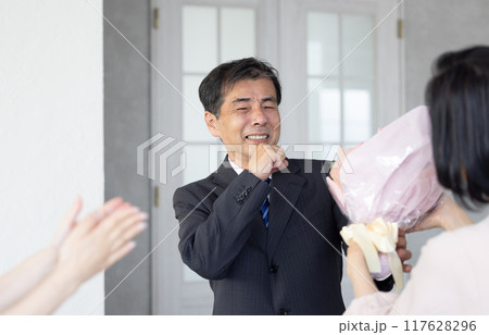 定年退職で家族から花束を受け取る父親 定年退職で家族から花束を受け取る父親 117628296