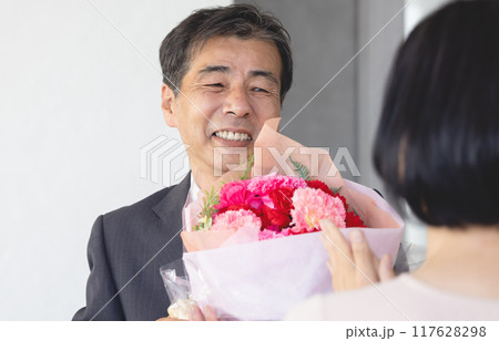 定年退職で家族から花束を受け取る父親 117628298