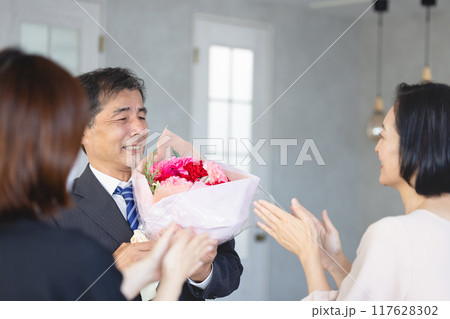定年退職で家族から花束を受け取る父親 定年退職で家族から花束を受け取る父親 117628302