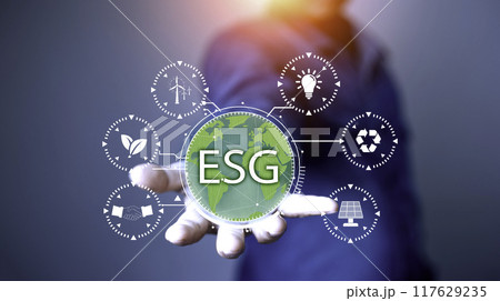 Net zero 2050 ESG concept, Hand with green world, wind energy system icon on blurred green leaf background. wind energy for green environment. Businessman background with energy icons around. 117629235