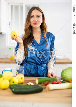 Portrait of positive woman eating apple at home 117630089