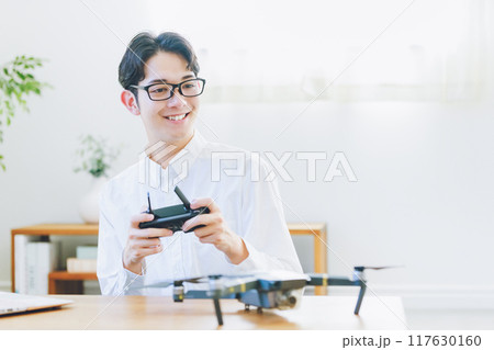 自宅でドローンの点検整備をする男性 117630160