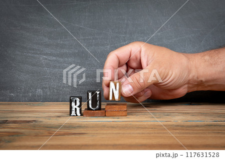 RUN. Wooden letters, alphabet blocks on steps. development and growth concept 117631528