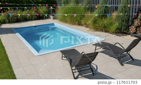 Modern backyard with a swimming pool and lounge chairs. 117631703