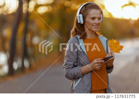 smiling elegant woman in fitness clothes in park smiling elegant woman in fitness clothes in park 117631775
