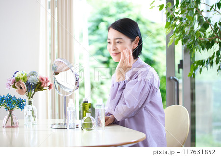 リビングでスキンケアをするミドル女性 リビングでスキンケアをするミドル女性 117631852