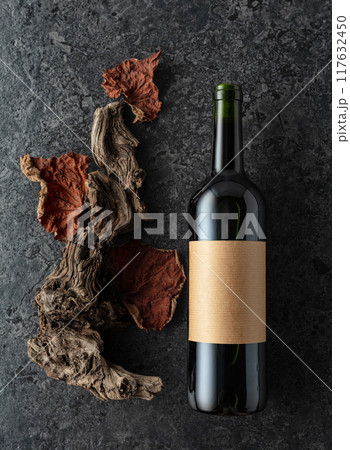 Bottle of red wine on a black stone background. 117632450
