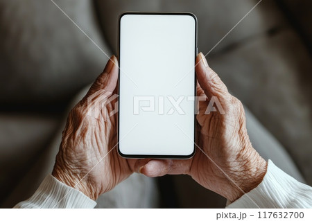 An elderly woman hands holding a smartphone with white screen 117632700