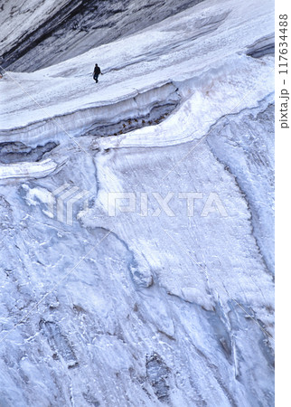 スイス　コルヴァッチ展望台から見た氷壁の側の雪渓を行く登山者 117634488