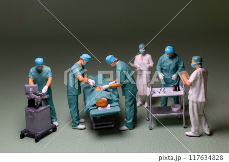 Miniature people, medical personnel surgery scene in progress, typical of an operating room environment. Miniature people, medical personnel surgery scene in progress, typical of an operating room environment. 117634828