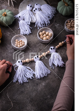 DIY craft Halloween garland in shape of ghost. 117635275