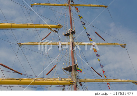 Masts and rigging of a sailing ship against sky with sailors. High quality photo 117635477