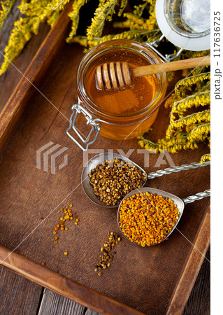 Bee honey and a wooden spoon. Sweet food. 117636725