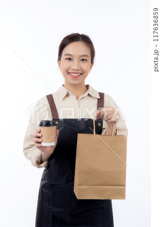 Young asian woman barista work attire happy holding a takeaway coffee cup and paper bag isolated. 117636859