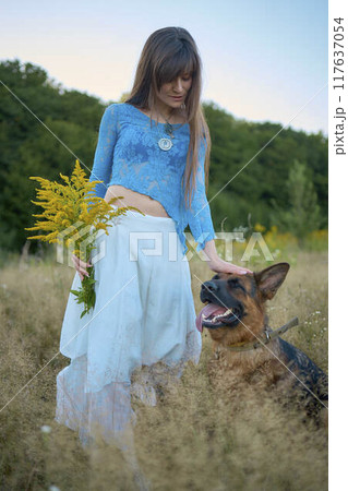 a woman in a Whimsical Aesthetic style dress with a German shepherd in a field 117637054