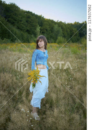 woman in whimsical aesthetic style dress in field in summer at sunset woman in whimsical aesthetic style dress in field in summer at sunset 117637062