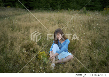woman in whimsical aesthetic style dress in field in summer at sunset woman in whimsical aesthetic style dress in field in summer at sunset 117637094