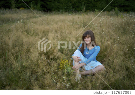 woman in whimsical aesthetic style dress in field in summer at sunset woman in whimsical aesthetic style dress in field in summer at sunset 117637095