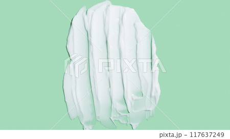 Beauty skincare cream texture swipe swatch. White beauty cream smear smudge isolated on green background 117637249