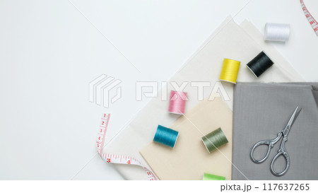 Composition with various threads and sewing accessories on white background 117637265