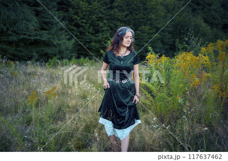 woman in whimsical aesthetic style dress in field in summer at sunset woman in whimsical aesthetic style dress in field in summer at sunset 117637462