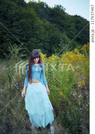woman in whimsical aesthetic style dress in field in summer at sunset woman in whimsical aesthetic style dress in field in summer at sunset 117637467