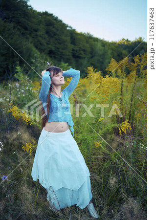 woman in whimsical aesthetic style dress in field in summer at sunset woman in whimsical aesthetic style dress in field in summer at sunset 117637468
