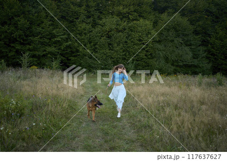a woman in a Whimsical Aesthetic style dress with a German shepherd in a field 117637627